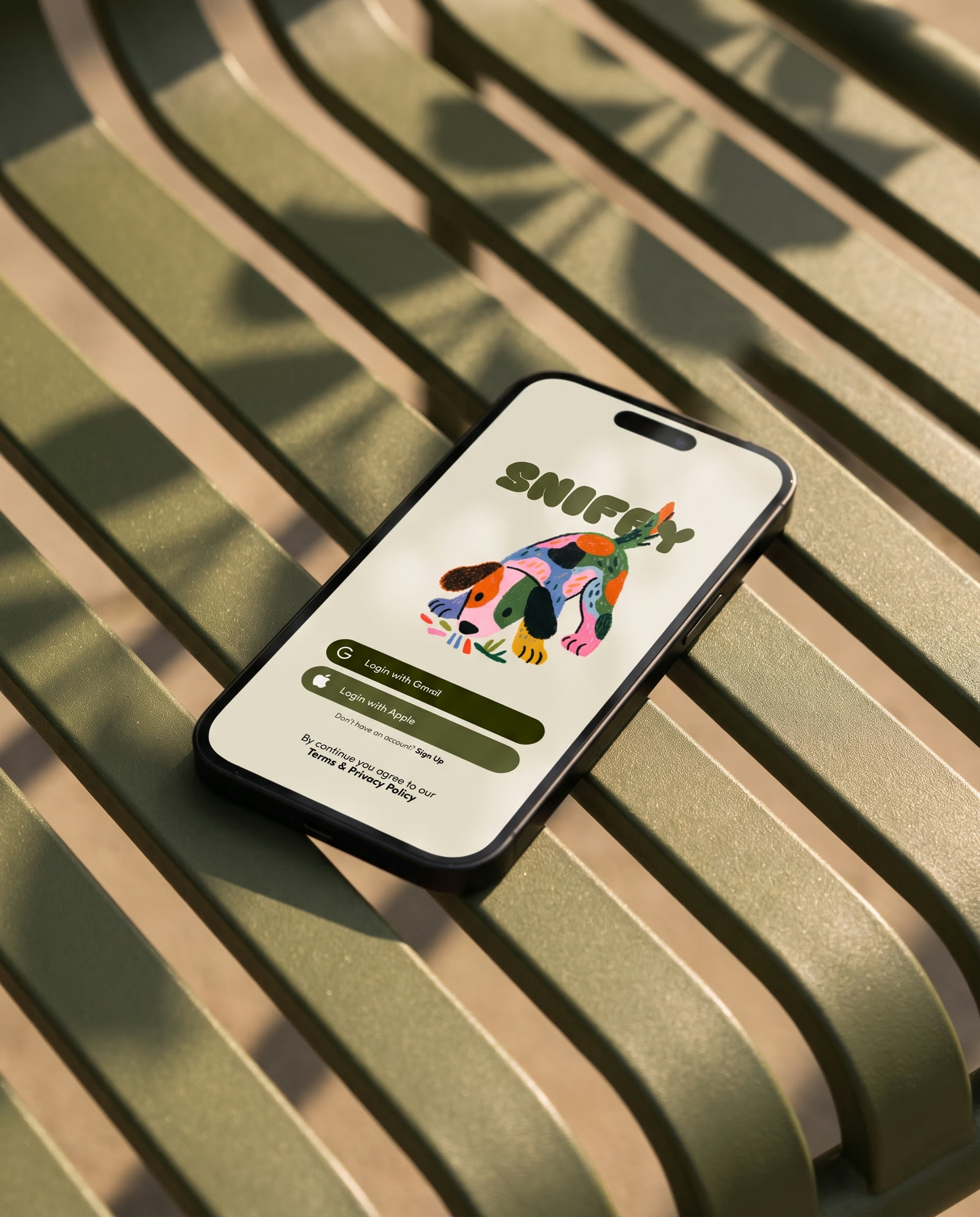 A phone open on the Sniffy sign in screen, lying on a green slatted bench in dappled sun